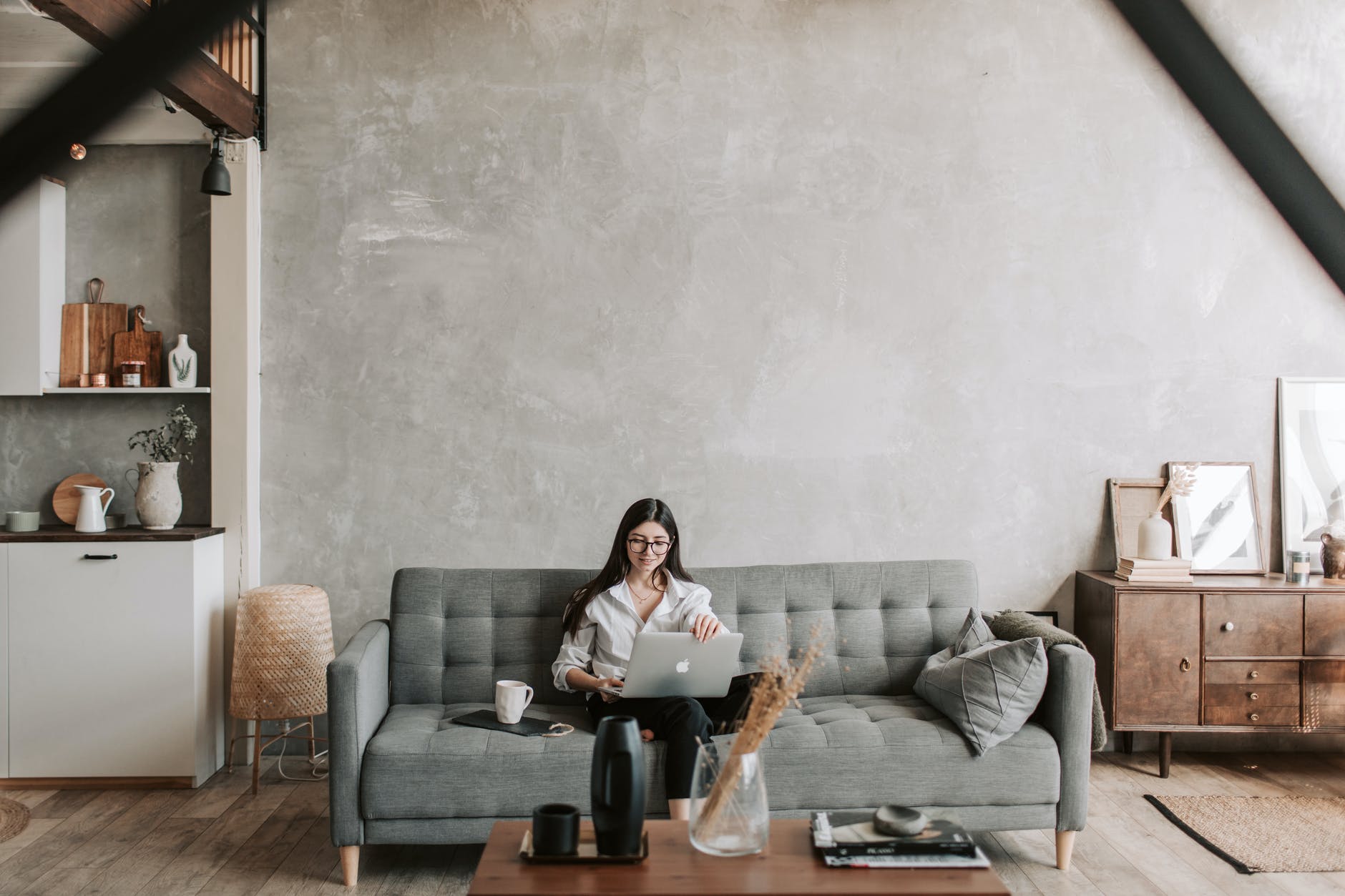 cheerful freelancer working on laptop in loft style apartment